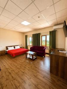a room with a bed and a couch and a tv at Uzumfermer Hotel & Winery in Tashkent