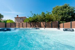 a large swimming pool in a backyard with a fence at Ombra in Bale