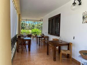 a dining room with wooden tables and chairs at Anna Rita Alghero B&B in Fertilia