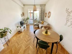 a living room with a table and a couch at Bright and central suite with a balcony in Brno +20 photos