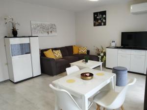 a living room with a couch and a table and chairs at Апартамент ДОРА in Kazanlŭk