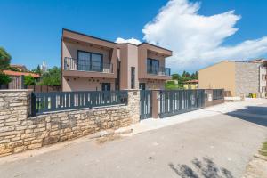 a house with a stone wall and a fence at Ombra in Bale