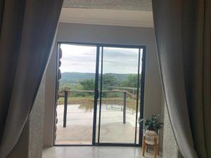 a room with a door to a balcony with a view at Hazyview Accommodation, Bon Repose Cottage 2 in Hazyview