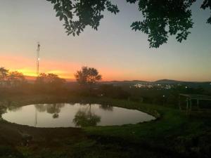 a small pond with a sunset in the background at Hazyview Accommodation, Bon Repose Cottage 2 in Hazyview +3 photos