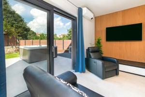 a living room with sliding glass doors and a tv at Ombra in Bale