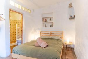 a bedroom with a bed and a bathroom with a toilet at Casa Lucía - Off grid vakantiehuisje - Puerto Mika in Torviscón