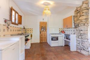 a kitchen with white appliances and a stone wall at Casa Lucía - Off grid vakantiehuisje - Puerto Mika in Torviscón +18 photos