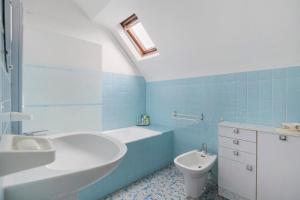 a blue bathroom with a sink and a toilet at Gîte Chez Madeleine in Coutances +18 photos