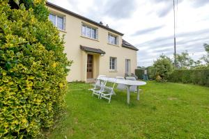 a garden with a table and chairs in front of a house at Gîte Chez Madeleine in Coutances
