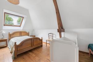 a bedroom with a bed and a chair in it at Gîte Chez Madeleine in Coutances