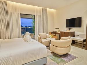 a hotel room with a bed and a living room at JP Crowne Regency in Pullappalli