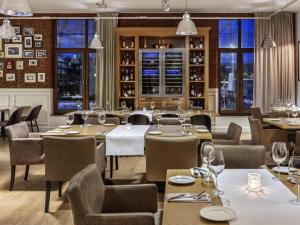 a restaurant with tables and chairs and windows at Mercure Wiazowna Brant in Wiązowna
