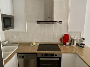 a kitchen with a sink and a stove top oven at Apartment Happy Coast Moraira in Moraira +12 photos