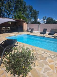 a swimming pool with chairs and a table at Tylyan in Le Thor +7 photos
