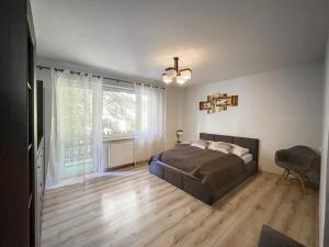a bedroom with a bed and a large window at Willa Kotelnica in Międzybrodzie Bialskie