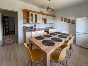 a kitchen with a wooden table with chairs and a refrigerator at Willa Kotelnica in Międzybrodzie Bialskie