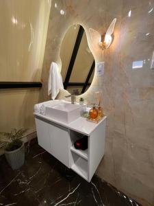 a bathroom with a white sink and a mirror at Chalés Alto Caparaó in Caparaó Velho