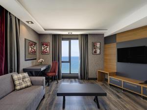 a living room with a couch and a television at Mövenpick Hotel Trabzon in Trabzon