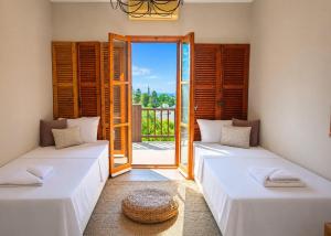 two beds in a room with an open door at Casablanca Villa by HolidayKeys in Kyrenia