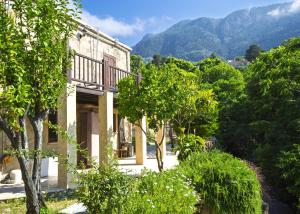 an old building with trees and mountains in the background at Casablanca Villa by HolidayKeys in Kyrenia