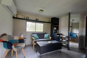 a living room with a couch and a table at Le Chalet du Lâcher-Prise in Éguzon-Chantôme