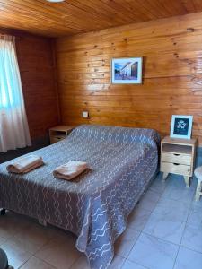 a bedroom with a bed and a wooden wall at Cabaña Cielo de Cachi in Cachí