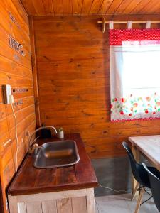 a kitchen with a sink in a wooden room at Cabaña Cielo de Cachi in Cachí