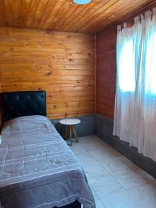 a bedroom with a bed and a window and a table at Cabaña Cielo de Cachi in Cachí