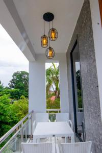 a white table and chairs on a balcony with a window at JJC BNB Mbweni in Bunju