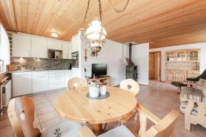a kitchen and dining room with a wooden ceiling at Alpine Apartment by Carista Homes in Habkern +4 photos