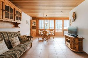a living room with a couch and a tv at Alpine Apartment by Carista Homes in Habkern