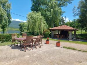 a wooden table and chairs and a gazebo at Guesthouse Gacka idila in Otočac +51 photos