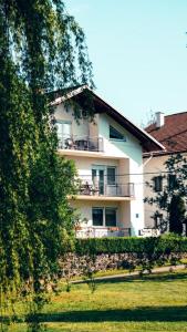a building with a balcony with chairs on it at Guesthouse Gacka idila in Otočac