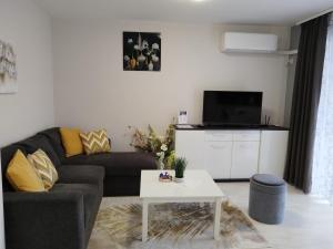 a living room with a couch and a coffee table at Апартамент ДОРА in Kazanlŭk
