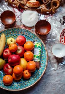 a plate of apples oranges and other fruits on a table at Юрта в аренду in Almaty +8 photos