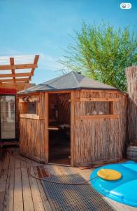 a wooden out house with a surfboard on a deck at Юрта в аренду in Almaty