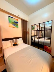 a bedroom with a large white bed and a window at Hope Residences by YsaRiCh Haven in Trece Martires +22 photos