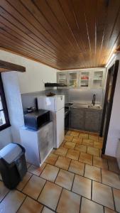 a kitchen with a white refrigerator and a tile floor at Coeur De Causse in Blars