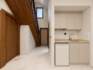 an empty kitchen with white cabinets and a staircase at Gölbaşı Garden Villa in Uzungöl