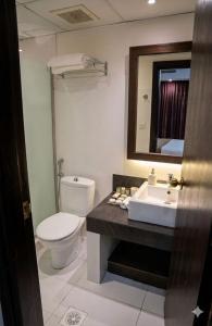 a bathroom with a toilet and a sink and a mirror at الا جنحة المخملية للشقق المخدومة - السلامة in Jeddah +43 photos