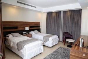 a hotel room with two beds and a desk at الا جنحة المخملية للشقق المخدومة - السلامة in Jeddah