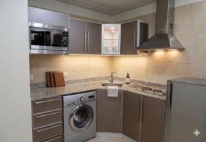 a kitchen with a washing machine and a sink at الا جنحة المخملية للشقق المخدومة - السلامة in Jeddah