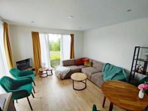 a living room with a couch and chairs and a tv at OV815- Chalet Eveline in Blokzijl
