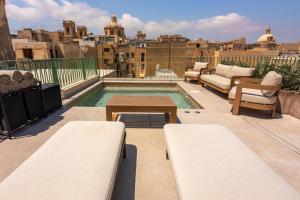 a rooftop patio with a pool on a building at The Vincent Boutique Hotel, BW Premier Collection in Valletta