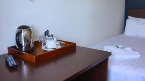 a wooden table with a coffee maker on top of a bed at Oban Hotel in Eastbourne