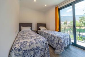 two beds in a room with a balcony at Villa Sasadi in Fethiye