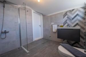 a bathroom with a shower and a toilet and a sink at Villa Sasadi in Fethiye +4 photos