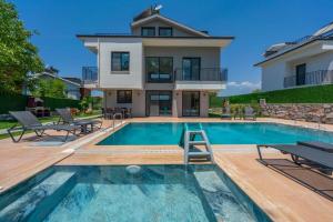 a home with a swimming pool and a house at Villa Sasadi in Fethiye