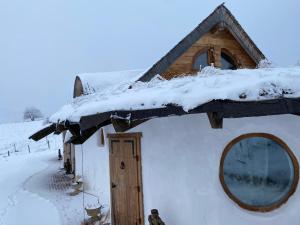 a snow covered roof of a house with a window at Casuta Letitiei in Şirnea