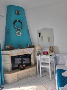 a living room with a fireplace and a blue wall at Athina Studios in Chorto +100 photos